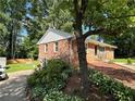 Rear exterior view of home, showing lush landscaping, brick and attached garage at 2059 Clearwater Se Dr, Marietta, GA 30067