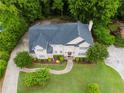 Aerial view of a home showing a well-maintained roof, expansive lawn, and driveway surrounded by lush trees at 2552 Berwick Walk, Snellville, GA 30078
