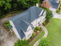A high angle of a home showcasing its roof, manicured lawn and landscaping, and lengthy driveway at 2552 Berwick Walk, Snellville, GA 30078