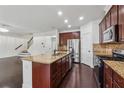 Spacious kitchen with granite countertops, stainless steel appliances, dark wood cabinets, and hardwood floors at 3700 Terrasol Sw Trl, Lilburn, GA 30047