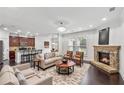 Open-concept living room with a stone fireplace, hardwood floors, modern lighting, and seamless flow to kitchen at 3700 Terrasol Sw Trl, Lilburn, GA 30047