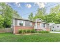 Charming single-story home featuring a brick facade, gray siding, landscaped front yard, and covered entryway at 947 Rebel Forest Dr, Atlanta, GA 30315