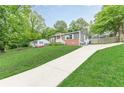 Charming single-story home with a long driveway, brick facade, gray siding, and well-manicured lawn at 947 Rebel Forest Dr, Atlanta, GA 30315