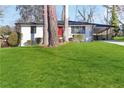 A white brick home with a vibrant red door, complemented by a lush green lawn and mature shade trees at 1796 Arkose Se Dr, Atlanta, GA 30316
