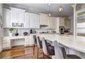 Open kitchen with a large island with seating, quartz countertops, white cabinets, and a stylish backsplash at 4206 Whitby Se Way # 15, Smyrna, GA 30080