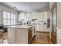 Bright white kitchen featuring an island with marble countertops, stainless steel appliances, and hardwood floors at 4206 Whitby Se Way # 15, Smyrna, GA 30080