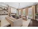 Inviting living room boasts stone fireplace, large windows, dark floors, and neutral color palette at 4538 Collins Ave, Sandy Springs, GA 30342
