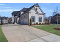 Wide concrete driveway leading to a three-car garage, surrounded by a lush, green lawn at 6355 Westfallen Overlook, Cumming, GA 30040