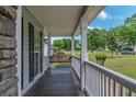 Inviting covered front porch with wooden swing, perfect for enjoying the outdoors at 102 Woodsfield Ln, Hiram, GA 30141
