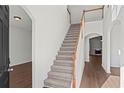 Welcoming foyer with a staircase featuring wood handrails and plush carpeting leading to the upper level at 221 Cutbank Sw Ct, Atlanta, GA 30331