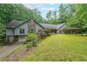 Beautifully landscaped home with an attached garage and well-maintained lawn and stone design features at 3601 Club Nw Dr, Kennesaw, GA 30144