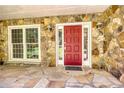 Inviting front entrance with a red door, stone facade, and elegant outdoor lighting fixtures at 3601 Club Nw Dr, Kennesaw, GA 30144