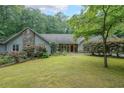 Single-story home featuring stone accents, mature landscaping, and a well-manicured lawn at 3601 Club Nw Dr, Kennesaw, GA 30144
