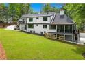 Rear exterior showcasing the lawn, patio, staircase, and screened-in porch at 1155 Peachtree Battle Nw Ave, Atlanta, GA 30327