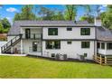 Backyard view of the home featuring a patio and expansive lawn and black-trimmed windows at 1155 Peachtree Battle Nw Ave, Atlanta, GA 30327