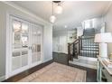 Elegant foyer with hardwood floors, stylish lighting, staircase, and decorative accents at 7455 Cordery Rd, Cumming, GA 30040
