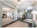 Elegant foyer with hardwood floors, stylish lighting, staircase, and opens to a living area at 7455 Cordery Rd, Cumming, GA 30040