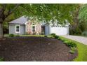 Charming single-Gathering home with stone accents and mature landscaping, including a lush lawn and vibrant flower beds at 1605 Barrier Rd, Marietta, GA 30066