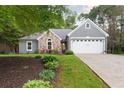 Charming home featuring a combination of stone and siding, complemented by a two-car garage and a well-maintained front yard at 1605 Barrier Rd, Marietta, GA 30066