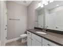 Modern bathroom featuring white cabinetry, a gray countertop, a large mirror, and a shower with white subway tiles at 313 Sassafras Way, Holly Springs, GA 30115