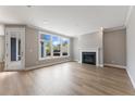 Bright living room with hardwood floors, a fireplace, large windows, and neutral paint at 313 Sassafras Way, Holly Springs, GA 30115