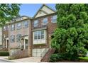 Attractive brick townhome featuring a two-car garage, bay window, and a welcoming entrance staircase at 2143 Yancey Ne Ln, Atlanta, GA 30319