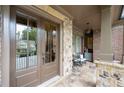 Charming covered porch with stone flooring, comfortable seating, and elegant architectural details at 2239 Tayside Nw Xing, Kennesaw, GA 30152