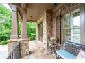 Covered entry with stone columns, stylish lighting, and cozy seating area on the front porch at 2239 Tayside Nw Xing, Kennesaw, GA 30152