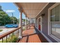 Inviting covered porch features classic columns, wood deck and access to the bright red front door at 3416 Harrison Rd, Atlanta, GA 30344