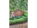 Community signage at Heritage Place adorned with lush greenery and manicured hedges at 211 Colonial Homes Nw Dr # 2203, Atlanta, GA 30309