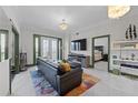 Bright living room featuring elegant lighting fixtures, doors to the patio, and an open doorway to the bedroom at 2255 Peachtree Ne Rd # 521, Atlanta, GA 30309
