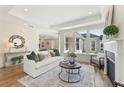 Elegant living room boasting a decorative fireplace, tray ceiling, and large windows for natural light at 309 Sassafras Way, Holly Springs, GA 30115