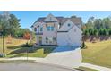 Picture of a two-story home with a well-manicured lawn, long driveway, and landscaping at 3440 Carswell Bnd, Cumming, GA 30028