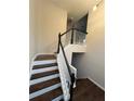 Staircase with wood treads and white risers and black handrail at 1015 Crest Ridge Sw Pl, Marietta, GA 30060