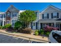 Attractive townhome boasts meticulous landscaping, charming shutters, and designated parking spaces at 1240 Kilmington Ct, Alpharetta, GA 30009
