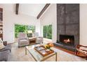 Bright living room showcasing a stone fireplace and large windows overlooking the private wooded backyard at 2075 Six Branches, Roswell, GA 30076