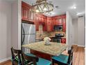 Well-equipped kitchen with cherry cabinets, stainless steel appliances, and cozy breakfast bar seating at 1421 Peachtree Ne St # 211, Atlanta, GA 30309