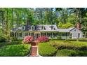Charming home with a manicured front lawn, mature trees, and traditional architectural details at 2890 Howell Mill Rd, Atlanta, GA 30327
