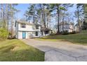 Split level home with ample parking and a lush lawn, nestled among mature trees at 3840 Natalie Way, Ellenwood, GA 30294