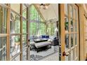 Cozy screened-in sunroom featuring neutral furniture, fan, string lights and beautiful outdoor views at 1595 Northcliff Trce, Roswell, GA 30076