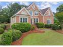 Beautiful brick home with manicured lawn, decorative bushes, and stunning architectural details at 1721 Mulberry Lake Dr, Dacula, GA 30019