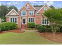 Charming brick home featuring a well-manicured lawn, landscaped bushes, and a classic architectural design at 1721 Mulberry Lake Dr, Dacula, GA 30019