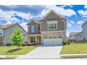 Attractive two-story home with stone accents, a green lawn, and a two-car garage, set against a bright sky at 3477 Ivy Birch Way, Buford, GA 30519