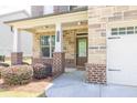 Inviting covered front porch featuring stone and brick accents, a perfect spot for relaxation and greeting guests at 3477 Ivy Birch Way, Buford, GA 30519