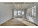 Bright living room featuring coffered ceilings, wood-look floors, and an abundance of natural light at 4032 Andover Cir, Mcdonough, GA 30252
