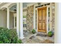 Elegant front entrance with a wooden door, stone accents, and a beautifully tiled porch at 3687 Canyon Ridge Ne Ct, Brookhaven, GA 30319