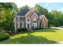 Charming two-story brick home featuring a beautifully landscaped front yard and classic architectural details at 3705 Rolling Creek Dr, Buford, GA 30519