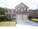 Inviting two-story home featuring a two-car garage and a cozy front porch, perfect for enjoying quiet moments at 4271 Haywater Cv, Buford, GA 30519