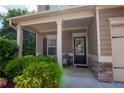 Charming covered front porch with decorative columns, stone accents, and cozy seating, creating a welcoming entrance at 4271 Haywater Cv, Buford, GA 30519