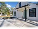 Close-up of home's front porch with a light-green door, black trim, and a freshly poured concrete porch at 2442 Connally Dr, East Point, GA 30344